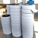 Floor scrubber gray roller wheels, multiple stacks of 200×50 mm wheels with textured tread, arranged in a warehouse setting.