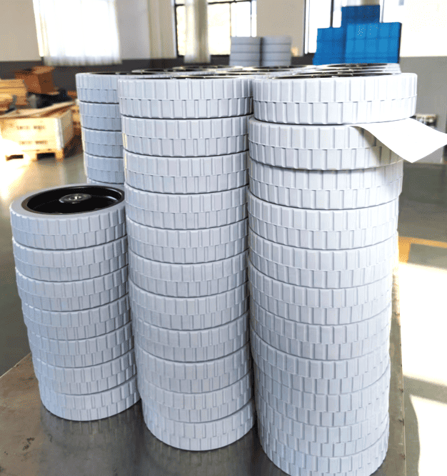 Floor scrubber gray roller wheels, multiple stacks of 200×50 mm wheels with textured tread, arranged in a warehouse setting.