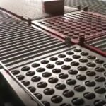 Industrial roller conveyor system, rubber wheel rollers combined with metallic tracks, facilitating smooth and precise movement of materials.