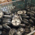Rubber wheels in metal storage bin, industrial caster wheels, warehouse inventory, ready for shipment or assembly.