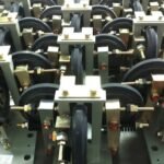 Elevator guide rollers, black rubber wheels with metal brackets, precision assembly for elevator systems, anti-vibration design.